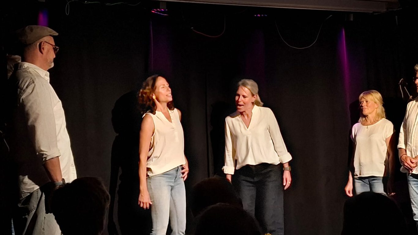 Improtheater Spontanika in Stormarn | Bühnenmoment Zwei Improtheater-Schauspielerinnen von Spontanika stehen nebeneinander auf der Bühne und blicken nach oben.
