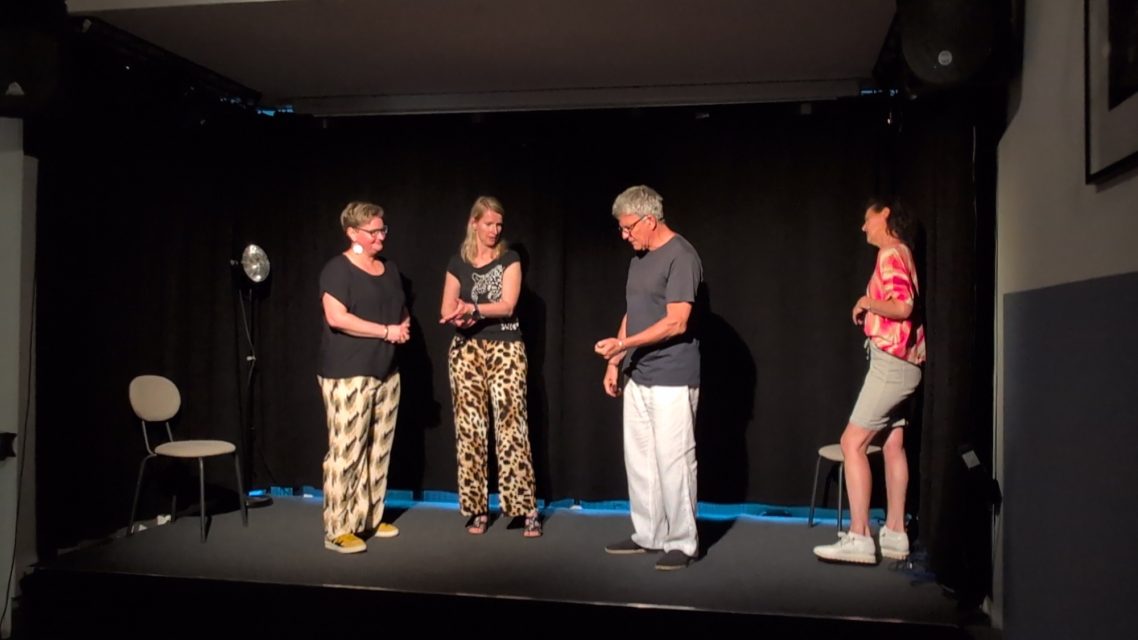 Improtheater Spontanika Ahrensburg – Improwerkstatt Bühne Vier Schauspieler der Improtheater-Gruppe Spontanika bei einer humorvollen Szene auf der Bühne während der Improwerkstatt in Ahrensburg.