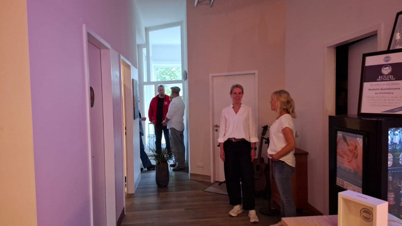 Einblick in den Backstage-Bereich Personen unterhalten sich im hellen Backstage-Flur vor dem Auftritt.