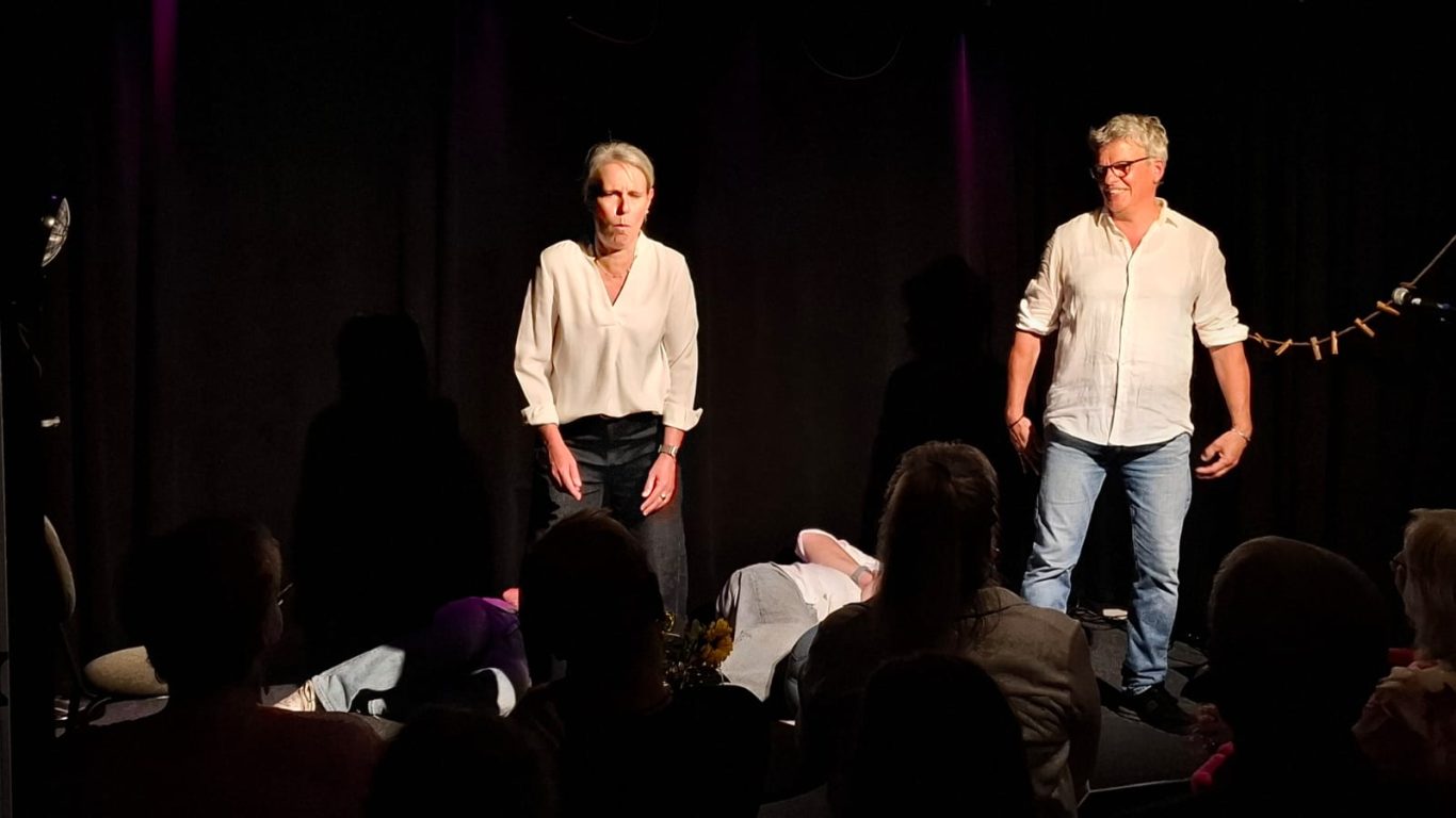 Impro-Game „Stirb!“ | Spontanika in Stormarn Spontanika-Darstellerinnen stehen auf der Bühne, während eine Person am Boden liegt – eine Szene aus dem Impro-Game „Stirb!“.