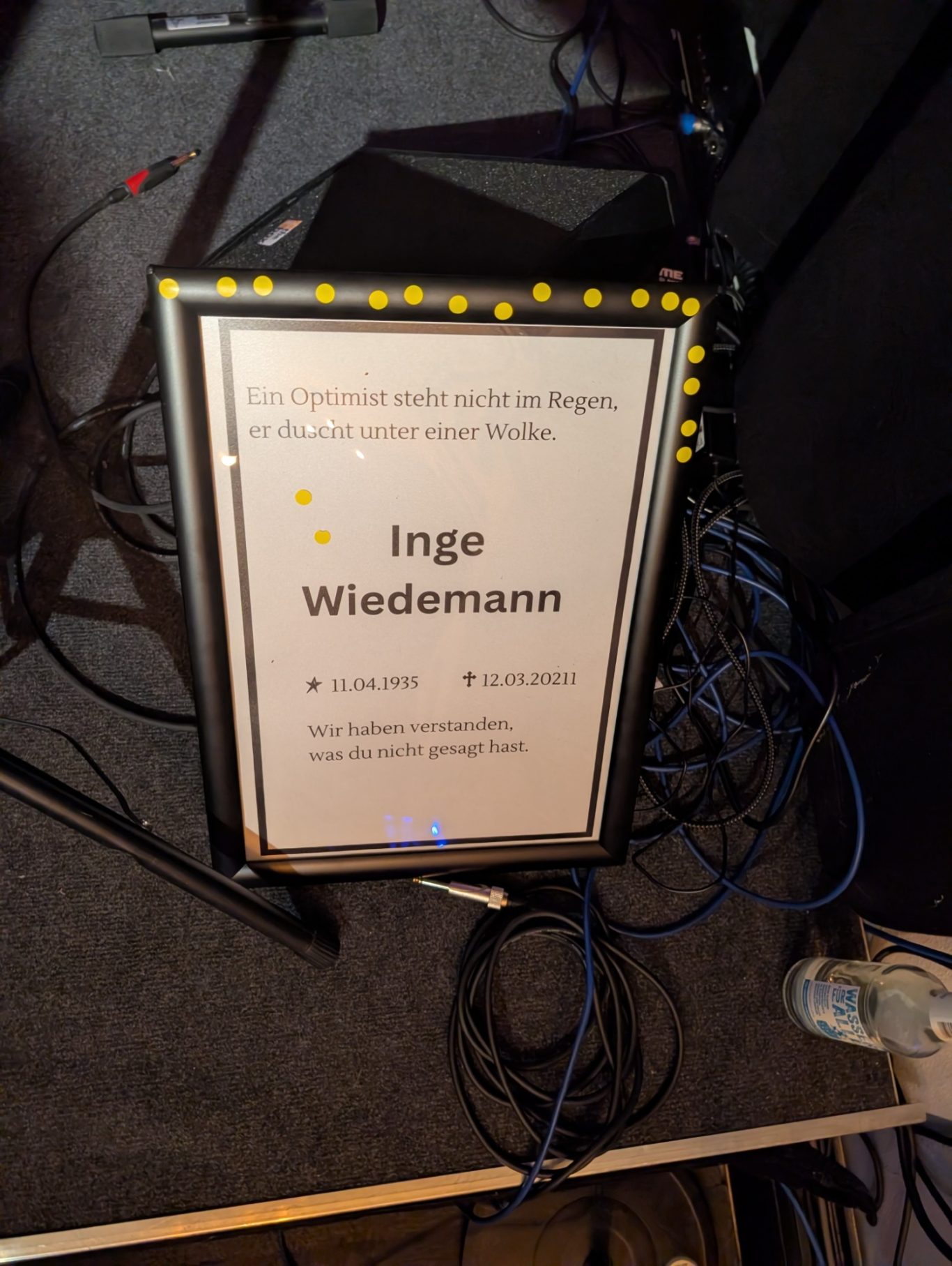 Vom Publikum gewählte Todesanzeige | Spontanika Gerahmte Todesanzeige für Inge Wiedemann, die als Inspiration für eine Theater-Langform auf einer Kiste steht.