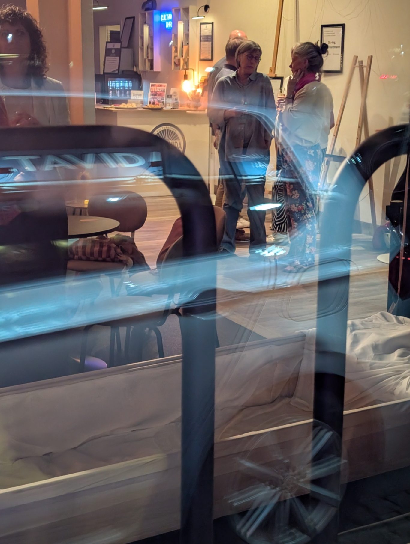 Blick ins Kultavida | Kulturbühne in Stormarn Blick von außen durch das Schaufenster der Kulturbühne Kultavida auf Gäste im Innenraum.