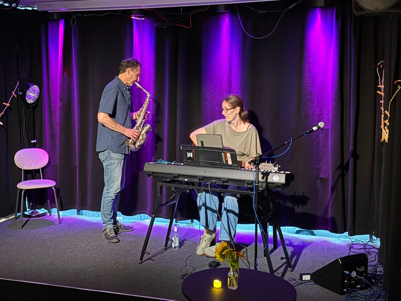 Stephanie Arndt und Kay bei „Das letzte Lachen“ im Kultavida Stephanie Arndt am E-Piano und Kay mit einem Saxophon auf der beleuchteten Bühne im Kultavida bei „Das letzte Lachen“
