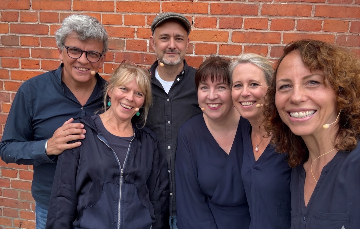 Gruppenfoto des Ensembles von Spontanika Improtheater vor einer Backsteinwand in Ahrensburg (Kreis Stormarn).
