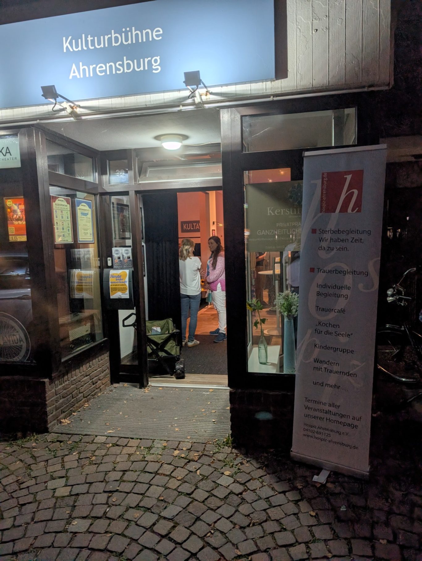 Blick ins Kultavida | Kulturbühne in Stormarn Blick von außen durch das Schaufenster der Kulturbühne Kultavida auf Gäste im Innenraum.