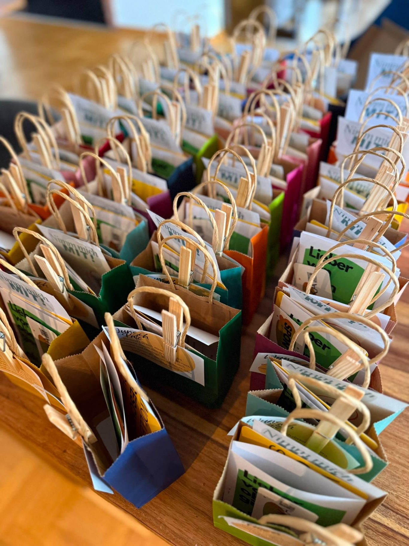 Bunte Give-Away-Tüten für das Publikum als Dankeschön Bunte Give-Away-Tüten mit Überraschungen auf einem Tisch aufgereiht.